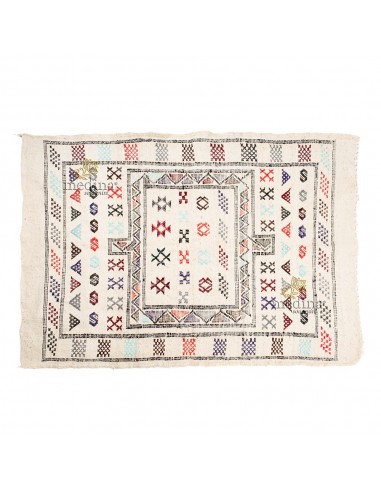 Tapis vintage fait main aux motifs ethniques sur fond blanc